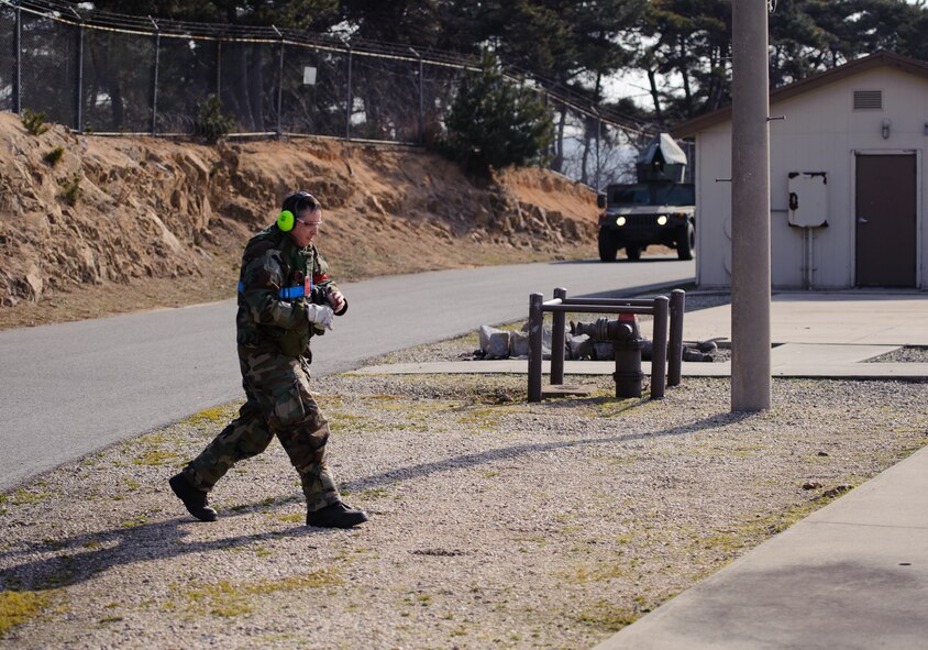Master Sgt. Billy Swartzel, 8th Fighter Wing Safety Office, walks to throw a smoke grenade during Beverly Midnight 14-01 at Kunsan Air Base, Republic of Korea, Feb. 6, 2014. Safety Airmen and wing inspection team members help test the base to continually be ready for anything, anytime. (U.S. Air Force photo by Senior Airman Armando A. Schwier-Morales/Released) 