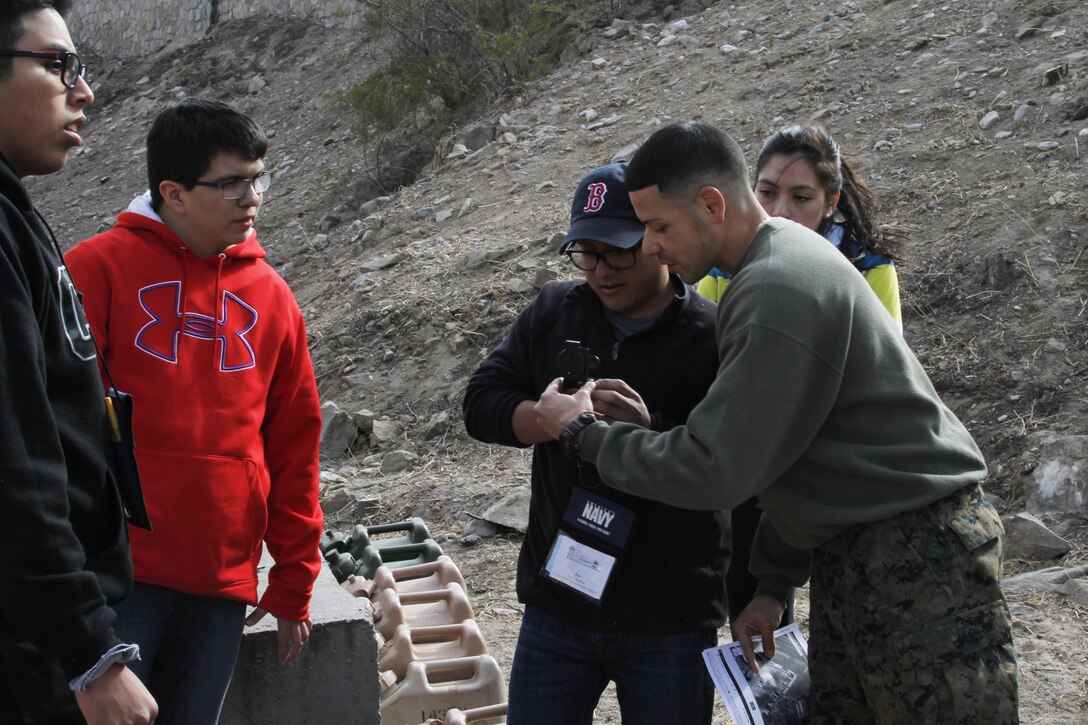 2nd Lt. Jose Valle, Marine Corps Recruiting Command MAES leadership
 conference trainer, instructs a MAES student on how to properly use a
 compass during an outdoor exercise at the University of Texas at El Paso, El
 Paso, Texas, Feb. 6. Developing traits that the Marine Corps excels in such
 as leadership, discipline and teamwork can provide MAES students guidance
 and professional growth for those who wish to better themselves