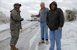 Army Sgt. Joshua White, 206th Engineer Battalion, talks with residents of Leitchfield, Ky., as part of a door-to-door health and welfare visit program conducted by members of the Kentucky National Guard.