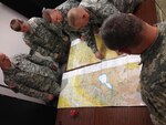 Soldiers from Headquarters and Headquarters Company, 38th Combat Aviation Brigade, tape map sets together for their warfighter exercise at Camp Atterbury Joint Maneuver Training Center, Jan. 22, 2014.