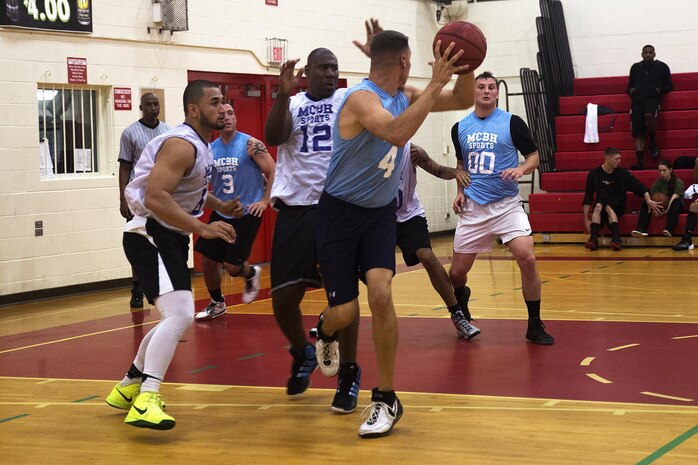 A 3rd Radio Battalion player looks for a teammate to pass the ball to during a fast-paced intramural basketball game at the Semper Fit Center gym, Feb. 4, 2014. (U.S. Marine Corps photo by Lance Cpl. Matthew Bragg)