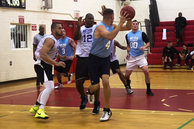 A 3rd Radio Battalion player looks for a teammate to pass the ball to during a fast-paced intramural basketball game at the Semper Fit Center gym, Feb. 4, 2014. (U.S. Marine Corps photo by Lance Cpl. Matthew Bragg)