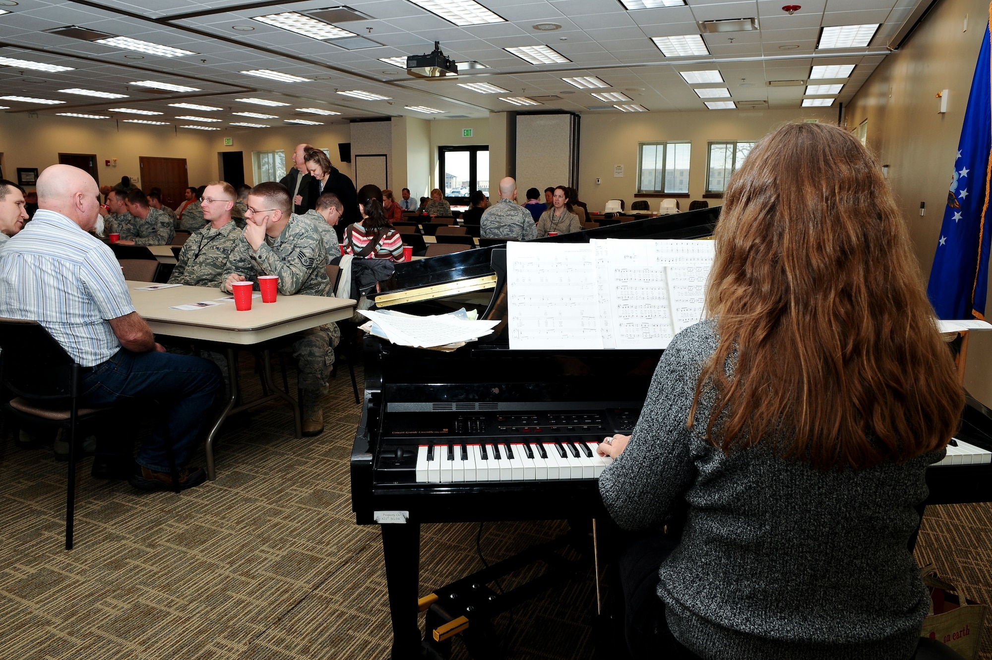 Katie Steinke, Buckley Chapel catholic community music director, plays the piano as members of Team Buckley prepare for the annual National Prayer Luncheon Feb. 5, 2014, at the chapel on Buckley Air Force Base, Colo. More than 350 Team Buckley members attended the luncheon, an annual event that encourages believers of any religion to seek their God through prayer. (U.S. Air Force photo by Senior Airman Phillip Houk/Released)