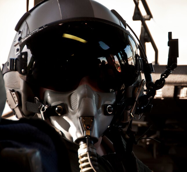 AJ Calisi tries on his very own flight safety helmet and mask in the cock pit of a C-17 Globemaster III prior to his simulated flight from Travis to Honolulu, Hi Jan. 31 as part of the Pilot for a Day program. (U.S. Air Force photo/Senior Airman Madelyn Brown)