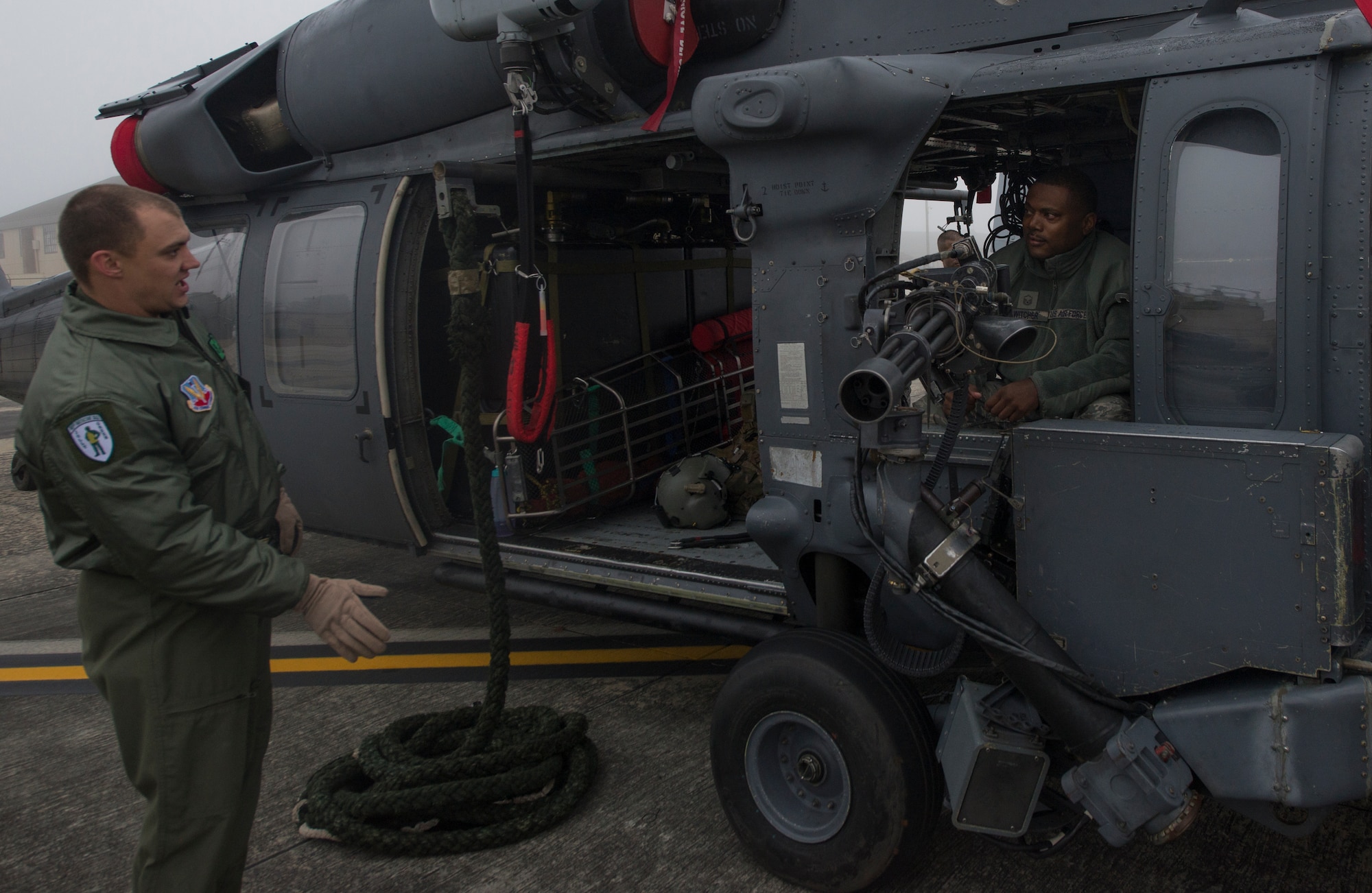 U.S. Air Force Master Sgt. Jason Mitchell, 23d Civil Engineer Squadron flight chief, is briefed by Staff Sgt. Matthew Lambert, 41st Rescue Squadron flight engineer, about the HH-60G Pave Hawk heavy machine gun during the Tour of Champions at Moody Air Force Base, Ga., Jan. 31, 2014. The Tour of Champions is for Annual Awards nominees to explore and learn about 23d Wing aircraft and operations. (U.S. Air Force photo by Airman Dillian Bamman/Released)
