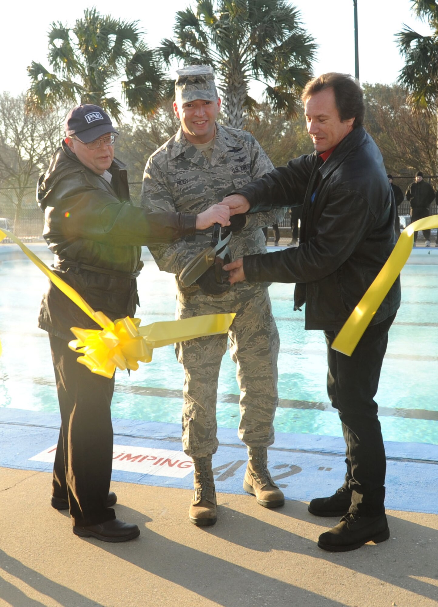 David Horner, PAE construction manager, Brig. Gen. Patrick Higby, 81st Training Wing, and David Budlong, PAE design engineer, participate in the heated triangle pool ribbon cutting ceremony Feb. 7, 2014, at Keesler Air Force Base, Miss.  The heated pool will allow Keesler’s battlefield Airmen students the ability to execute water skills training without impeding on the limited time the students have in the morning for physical training before starting their academic day.   Prior to the heater being installed, the Airmen had to use an off base facility.  (U.S. Air Force photo by Kemberly Groue)