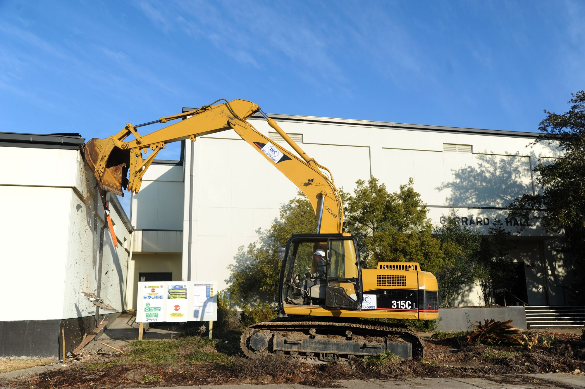 Brig. Gen. Patrick Higby, 81st Training Wing commander, operates an excavator to begin the demolition of Garrard Hall Feb. 7, 2014, at Keesler Air Force Base, Miss.  The estimated completion date is by the end of May and the property will be returned to green space.  (U.S. Air Force photo by Kemberly Groue)