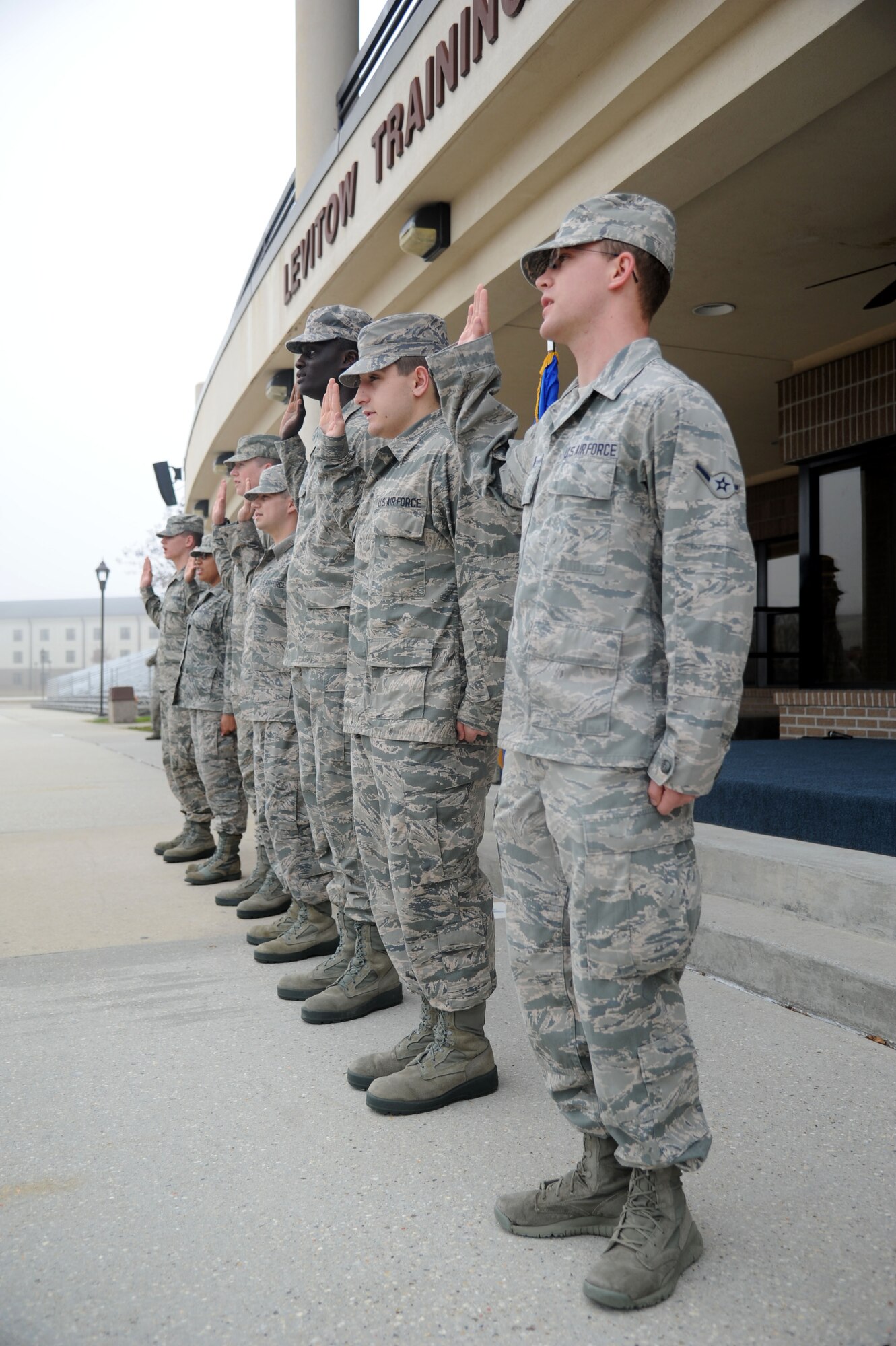 Seven of the 20 Training Group’s newest Airmen promotees repeat the oath of enlistment as it is administered by Col. George Tombe, 81st Training Group commander, during a dragon recognition presentation Feb. 4, 2014, behind the Levitow Training Support Facility, Keesler Air Force Base, Miss.  The ceremony reinforced their commitment as they take on new responsibilities with their promotion. The event also included the announcements of Airman of the Month and military training flight of the Month for January.  (U.S. Air Force photo by Kemberly Groue)