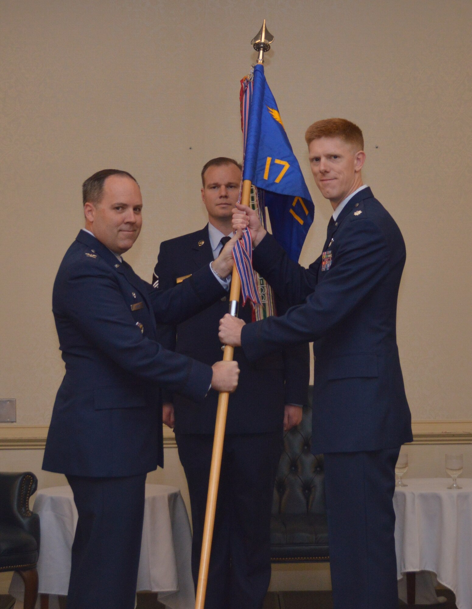 Col. Frederick Boehm, 437th Operations Group commander, hands the 17th Airlift Squadron guidon to Lt. Col. Paul Theriot, during the 17th AS change of command ceremony Feb. 6, 2014, at the Charleston Club on Joint Base Charleston – Air Base. Theriot relieved Lt. Col. Todd Groomes. (U.S. Air Force photo/ Senior Airman Wesley Woods)