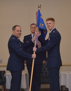 Col. Frederick Boehm, 437th Operations Group commander, hands the 17th Airlift Squadron guidon to Lt. Col. Paul Theriot, during the 17th AS change of command ceremony Feb. 6, 2014, at the Charleston Club on Joint Base Charleston – Air Base. Theriot relieved Lt. Col. Todd Groomes. (U.S. Air Force photo/ Senior Airman Wesley Woods)