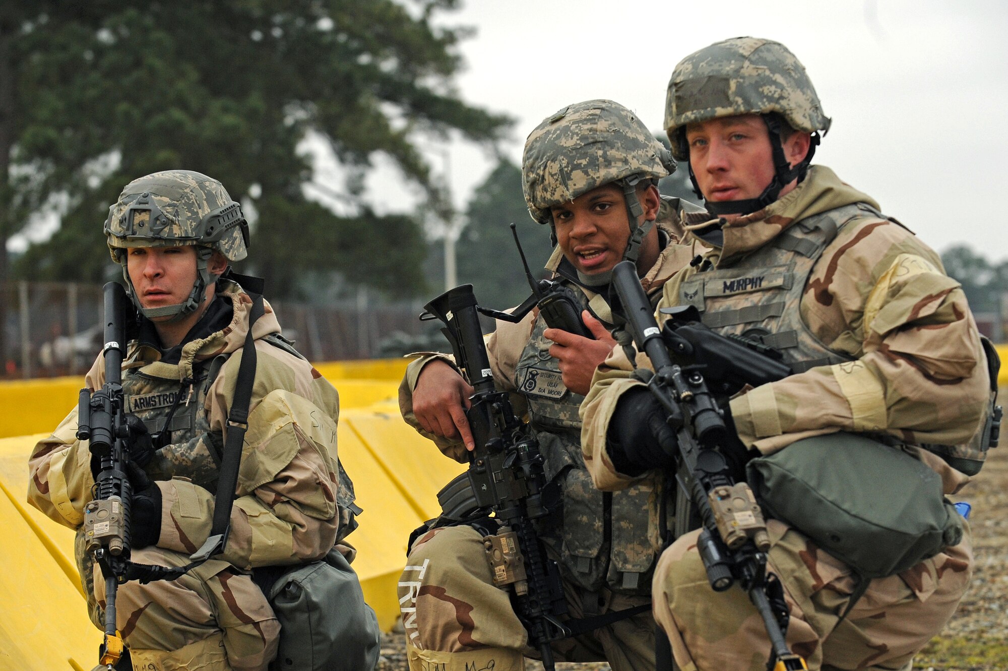 Airman 1st Class Eli Armstrong, left, Senior Airman Emmanuel Moore and Airman 1st Class Neil Murphey, 4th Security Forces Squadron patrolmen, secure the main entry control point of a simulated base during Employment Exercise Coronet Warrior 14-01, Feb. 4, 2014, at Seymour Johnson Air Force Base, N.C. Security forces members guarded the exercise site against ground attacks. (U.S. Air Force photo by Airman 1st Class Aaron J. Jenne)