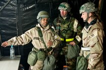 From left, Staff Sgt. Latasha Carmouche, 4th Force Support Squadron resource advisor, leads Chief Master Sgt. Jeffrey Craver, 4th Fighter Wing command chief, and Col. Jeannie Leavitt, 4th FW commander, on a tour of the dining facility during Employment Exercise Coronet Warrior 14-01, Feb. 5, 2014, at Seymour Johnson Air Force Base, N.C.  Leavitt and Craver visited a variety of tents at the exercise play area to check on Airmen and boost morale.  (U.S. Air Force photo by Airman 1st Class Brittain Crolley)