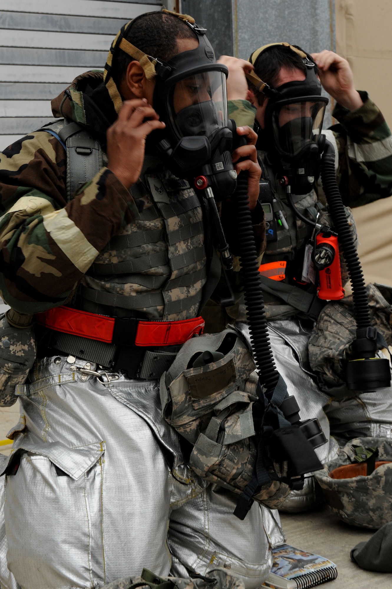 Senior Airman Ray Denson, left and Airman 1st Class Michael Gilligan don gas masks during Employment Exercise Coronet Warrior 14-01, Feb. 4, 2014, at Seymour Johnson Air Force Base, N.C. During the exercise, Airmen were tested on their reactions and appropriate responses to changing threat conditions. (U.S. Air Force photo by Airman 1st Class Aaron J. Jenne)
