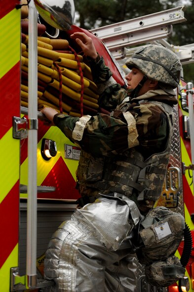 Airman 1st Class Christopher Parker, a 4th Civil Engineer Squadron firefighter, inspects a fire engine hose during an employment exercise, at Seymour Johnson Air Force Base, N.C. Firefighters are required to check equipment prior to dispatching in order to ensure that they are functional and properly secured. (U.S. Air Force photo by Airman 1st Class Aaron J. Jenne)