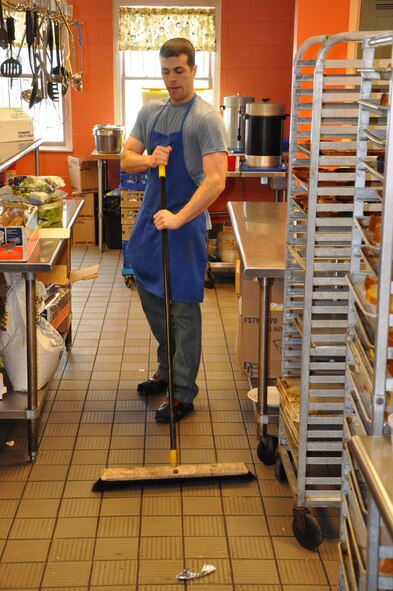 Airman 1st Class Austin Shiplet from the 88 Medical Support Squadron cleans the floor at the House of Bread in Dayton, Ohio, where he volunteered to help the community kitchen to prepare, server and clean the kitchen with nine other Airmen from Wright-Patterson AFB. (USAF photo by Ted Theopolos)