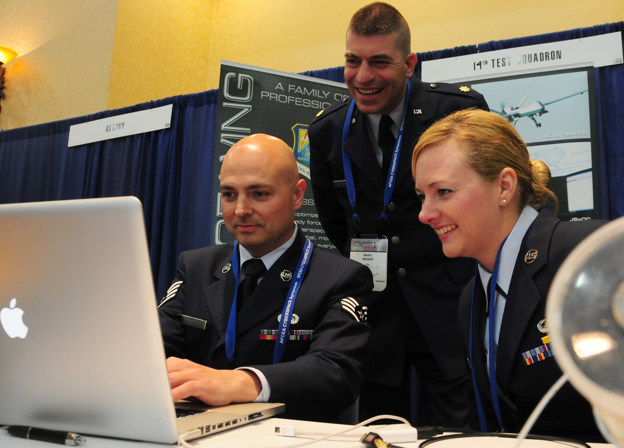Air Force Reserve Maj. Marc Weber looks on as Staff Sgt. Tim Teller and Tech. Sgt. Krystal Porter generate computer code Feb. 5, 2014, during the annual Armed Forces Communication and Electronics Association symposium at the Broadmoor Hotel in Colorado Springs, Colo. Teller and Porter, both test managers with the 14th TS, together with Weber, highlighted the 14th TS's mission of "blue-team testing" and configuration to symposium attendees. Hosted by the Rocky Mountain Chapter of the AFCEA organization, the symposium aims to bring together government and industry officials for cyber and information technology-related needs, exposing both to the needs of the Department of Defense while highlighting the latest technology advancements from the private sector. Weber is the 14th TS's technical director. (U.S. Air Force photo/Tech. Sgt. Stephen J. Collier)