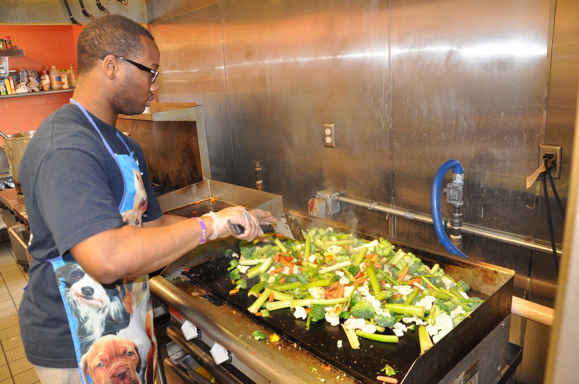 Airmen 1st Class Richard Militon, assigned to the U.S. Air Force School of Aerospace Medicine, cooks mixed vegetables at the House of Bread community kitchen in Dayton, Ohio.  Airmen from Wright-Patterson AFB volunteer organization Airmen Breaking Bread volunteered for the day to prepare and serve lunch. (USAF photo by Ted Theopolos)