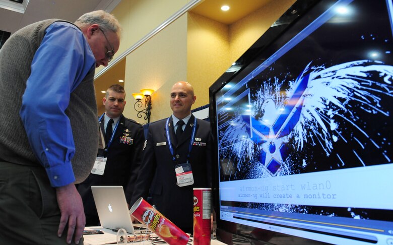 Air Force Reserve Staff Sgt. Tim Teller showcases the "Cantenna" to visitors at his 14th Test Squadron booth Feb. 5, 2014, during the annual Armed Forces Communication and Electronics Association symposium at the Broadmoor Hotel in Colorado Springs, Colo. Teller, a test manager with the 14th TS, together with Maj. Marc Weber, showcase the Cantenna, a converted potato chip can that can receive Wi-Fi signals. Hosted by the Rocky Mountain Chapter of the AFCEA organization, the symposium aims to bring together government and industry officials for cyber and information technology-related needs, exposing both to the needs of the Department of Defense while highlighting the latest technology advancements from the private sector. Weber is the 14th TS technical director. (U.S. Air Force photo/Tech. Sgt. Stephen J. Collier)