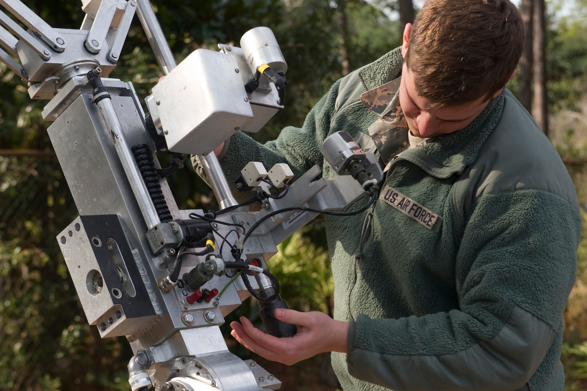 An Airman with the 1st Special Operations Civil Engineer Squadron explosive ordnance disposal screws the breach onto an F-6 robot during training at Hurlburt Field, Fla., Feb. 6, 2014. The breach houses the fire pin inside, which is set off by the pressure of a shock tube. (U.S. Air Force photo/Senior Airman Naomi Griego)