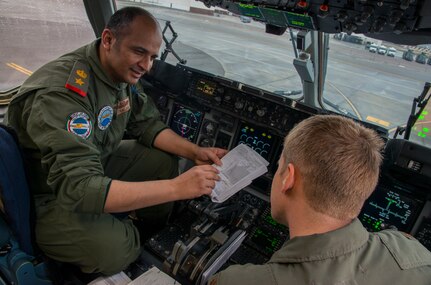 Lt. Col. Talaq Al-Otaibi (left), Kuwaiti Air Force’s 41st Transport Squadron pilot, and Maj. Eric Peterson, 17th Airlift Squadron pilot, go over flight plans prior to take-off Feb. 5, 2014, on a C-17 Globemaster III at Joint Base Charleston – Air Base, S.C. The Kuwait Air Force recently purchased a second C-17 and 17th AS Airmen were to familiarize the Kuwait flight crew on the operations and maintenance of the C-17. (U.S. Air Force photo/ Airman 1st Class Clayton Cupit)