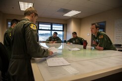 Major Eric Peterson (left), 17th Airlift Squadron pilot, briefs the Kuwait flight crew on weather conditions prior to take-off Feb. 5, 2014, at the 17th AS Operations briefing room on Joint Base Charleston – Air Base, S.C. The Kuwait Air Force recently purchased a second C-17 Globemaster III and 17th AS Airmen were to familiarize the Kuwait flight crew on the operations and maintenance of the C-17. (U.S. Air Force photo/ Airman 1st Class Clayton Cupit)