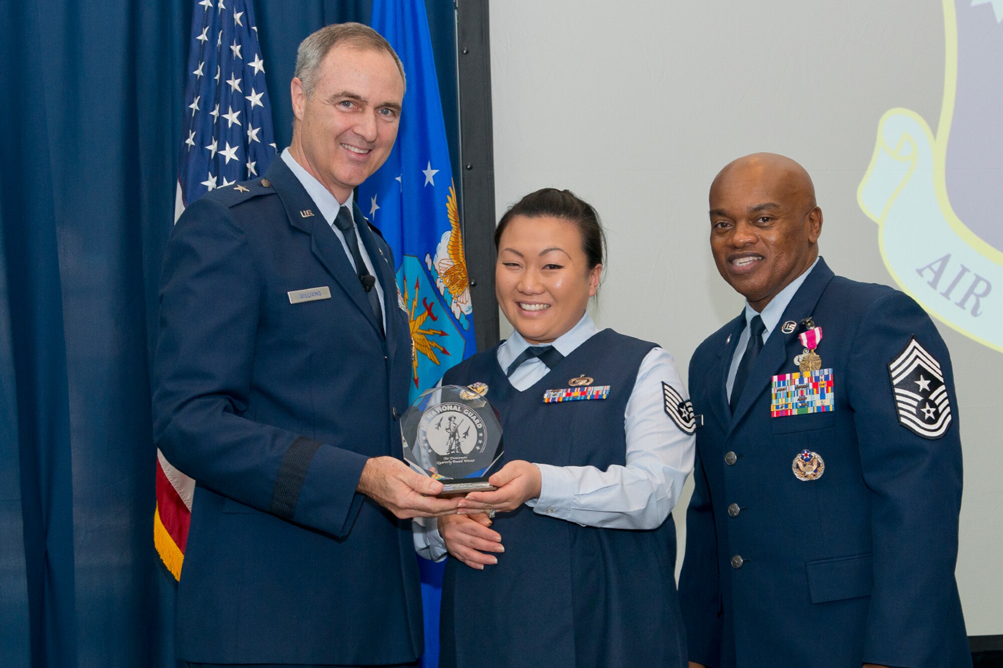 Brig. Gen. R. Scott Williams, the commander of the Air National Guard Readiness Center, and Chief Master Sgt. Tony L. Whitehead, the command chief master sergeant of the ANGRC, present the Non-Commissioned Officer of the Quarter to Tech. Sgt. Daniela W. Ricci, ANGRC Intelligence, Surveillance and Reconnaissance, during the ANGRC 4th Quarter Awards Ceremony and Commander’s Call Feb. 6, 2014, at the ANGRC, Joint Base Andrews, Md. The ceremony hosted by Williams recognizes the accomplishments of the ANGRC staff. (U.S. Air National Guard photo by Master Sgt. Marvin R. Preston/RELEASED)