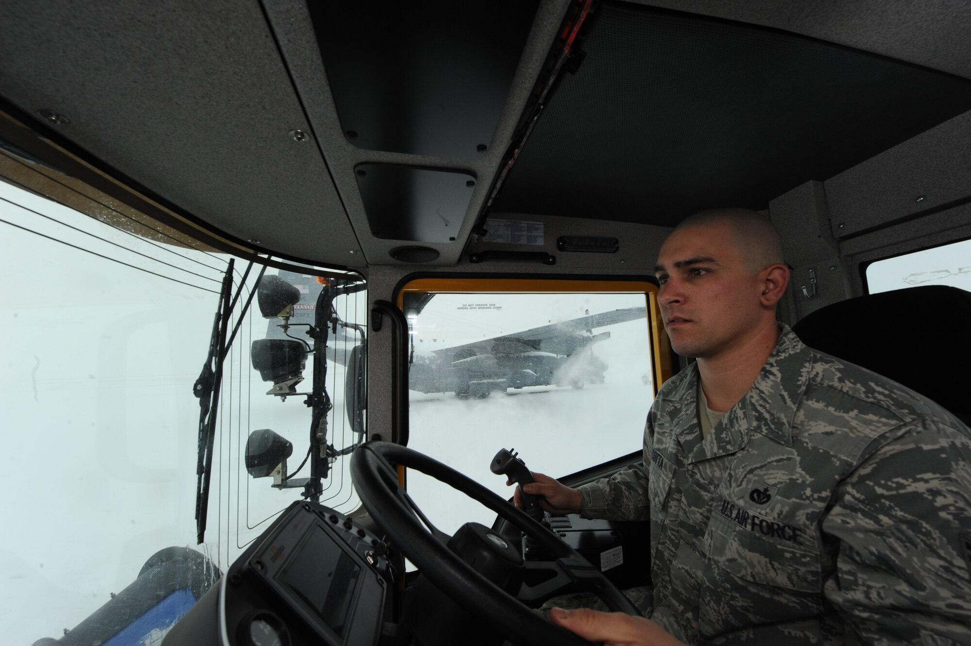 PETERSON AIR FORCE BASE, Colo. -- Staff Sgt. Matthew Cincotta, 21st Civil Engineer Squadron heavy equipment vehicle operator, uses a snow plow to remove snow from the flightline here Feb. 4. The 21st CES has four plows specifically for the flightline. Heavy equipment vehicle operators work in teams of three or four to clear the flightline as quickly as possible. (U.S. Air Force photo/Staff Sgt. Jacob Morgan)