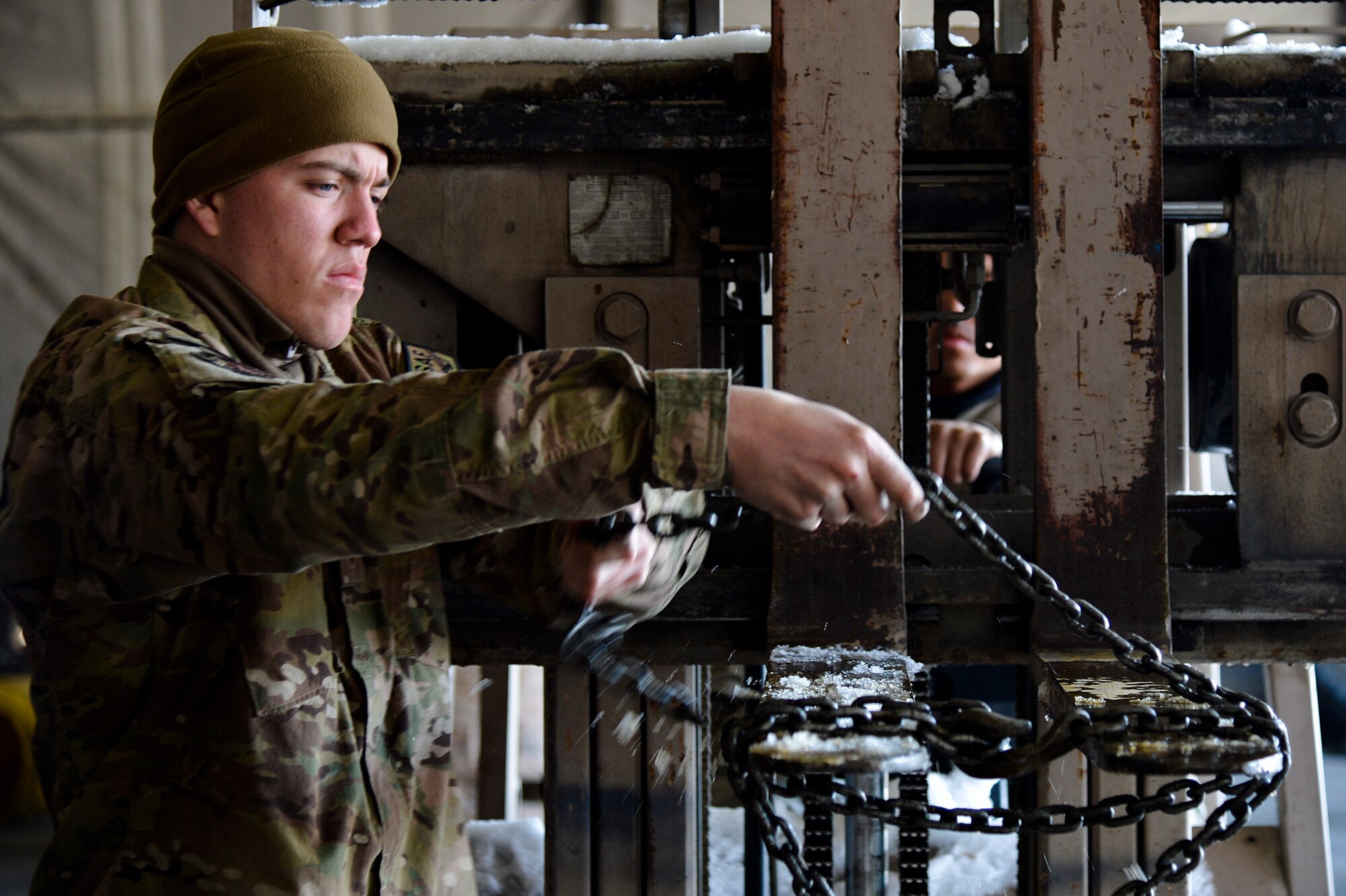 U.S. Air Force Senior Airman Michael Siters, 455th Expeditionary Logistics Readiness Squadron, secures chains on a forklift at Bagram Airfield, Afghanistan, Feb. 7, 2014. The vehicle maintenance shop is responsible for maintaining and repairing vehicles that are vital to the mission at Bagram. (U.S. Air Force photo by Senior Airman Kayla Newman/Released)