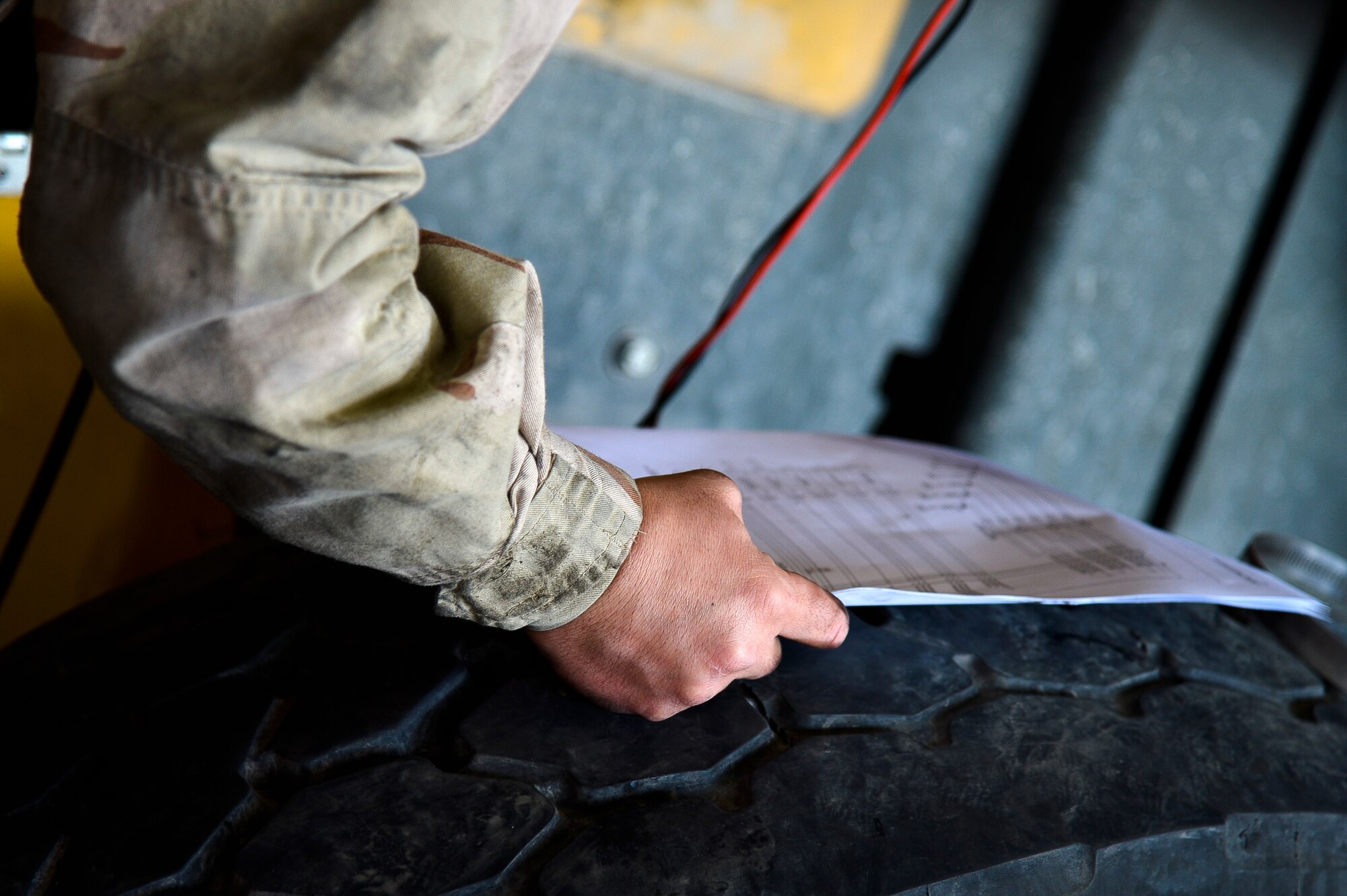 U.S. Air Force Staff Sgt. Jayme Smithee, 455th Expeditionary Logistics Readiness Squadron vehicle mechanic, references a manual about electronic fuel injection wiring at Bagram Airfield, Afghanistan, Feb. 7, 2014. The vehicle maintenance shop is responsible for maintaining and repairing vehicles that are vital to the mission at Bagram. Smithee is deployed from Vandenberg Air Force Base, Calif.  (U.S. Air Force photo by Senior Airman Kayla Newman/Released)