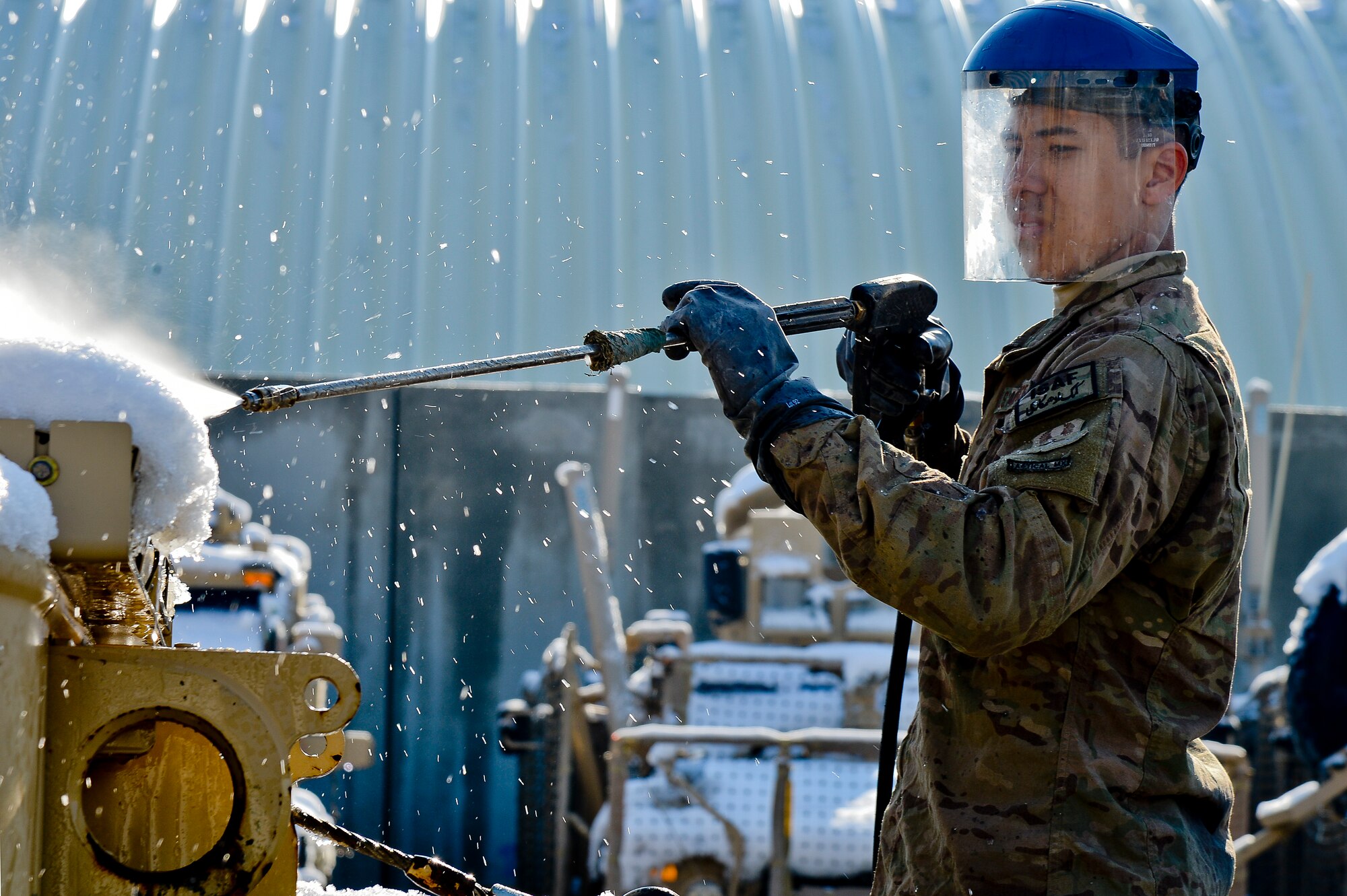 U.S. Air Force Airman 1st Class Anthony Wright, 455th Expeditionary Logistics Readiness Squadron, pressure washes a Mine-Resistant Ambush Protection vehicle at Bagram Airfield, Afghanistan, Feb. 7, 2014. MRAPs must be washed and have maintenance done before they can be shipped out of Bagram. (U.S. Air Force photo by Senior Airman Kayla Newman/Released)