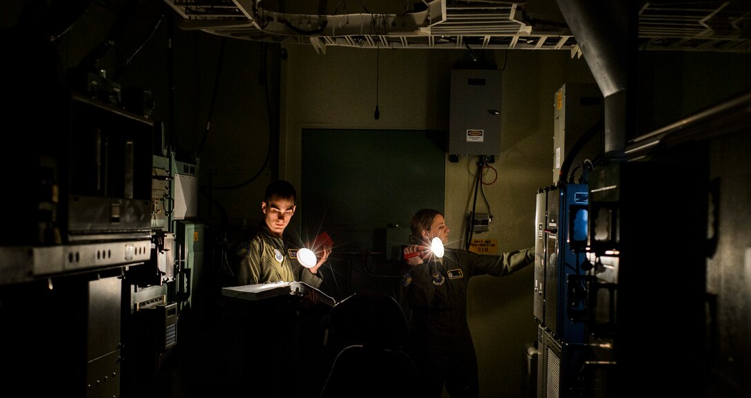 Capt. Robert Shannon, 341st Operations Support Squadron missile combat crew commander, and Capt. Brooke Lake, 341st  OSS missile combat crew commander instructor, go through a launch procedure checklist during simulation training at Malmstrom Air Force Base, Mont., Feb. 6, 2014. The 341st OSS trains missile crews, missile alert facility managers and chefs to ensure they are proficient and combat ready. (U.S. Air Force photo by Staff Sgt. Jonathan Snyder/RELEASED)