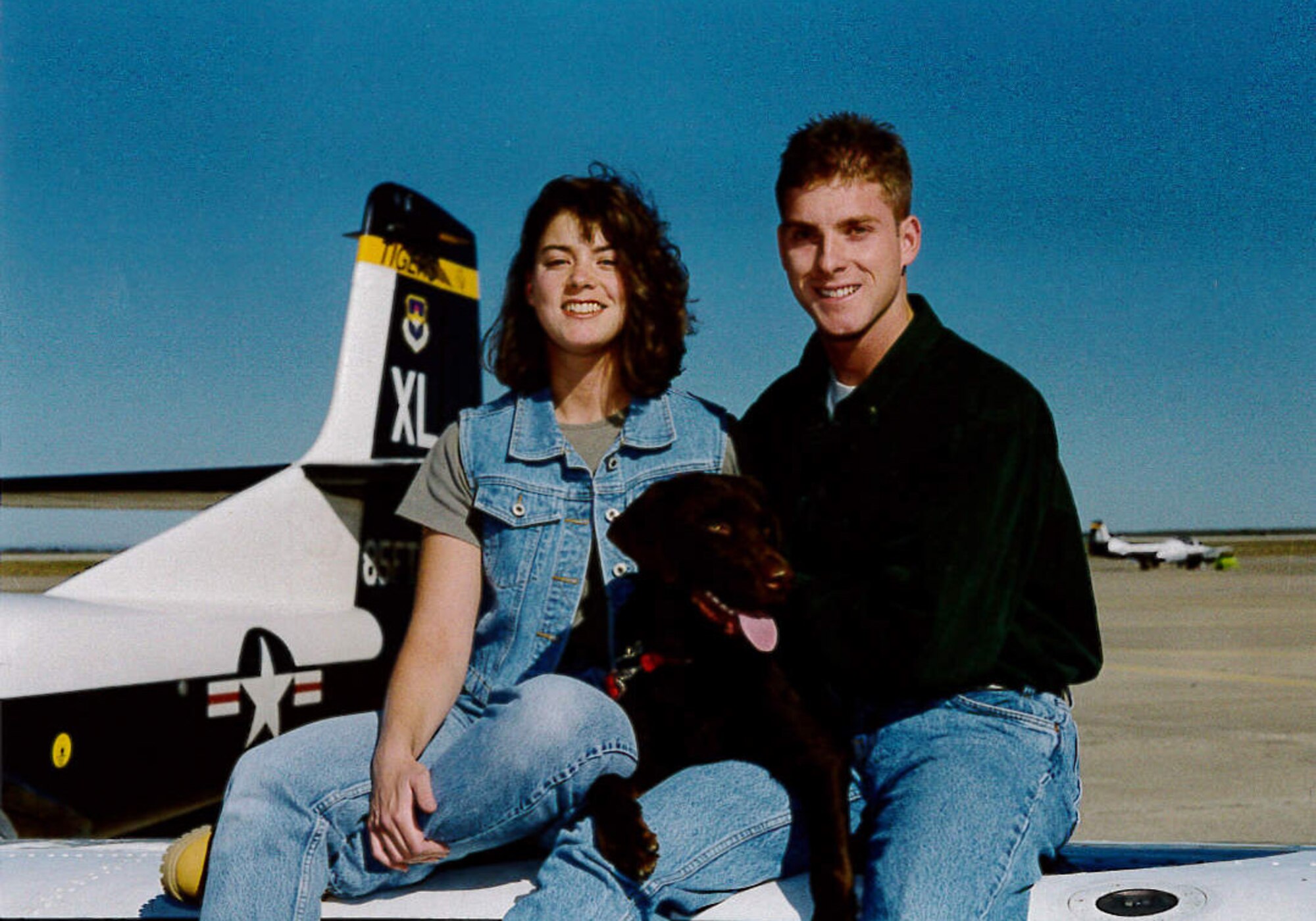 Maj. (Dr.) Jeffrey Woolford and his wife Nicole pose for a photo with their dog on top of a test pilot aircraft. Woolford began his career in the Air Force as an enlisted crew chief. He is now one of 12 pilot-physicians and is currently attending Johns Hopkins University to earn his Master’s Degree in Public Health. (U.S. Air Force courtesy photo)