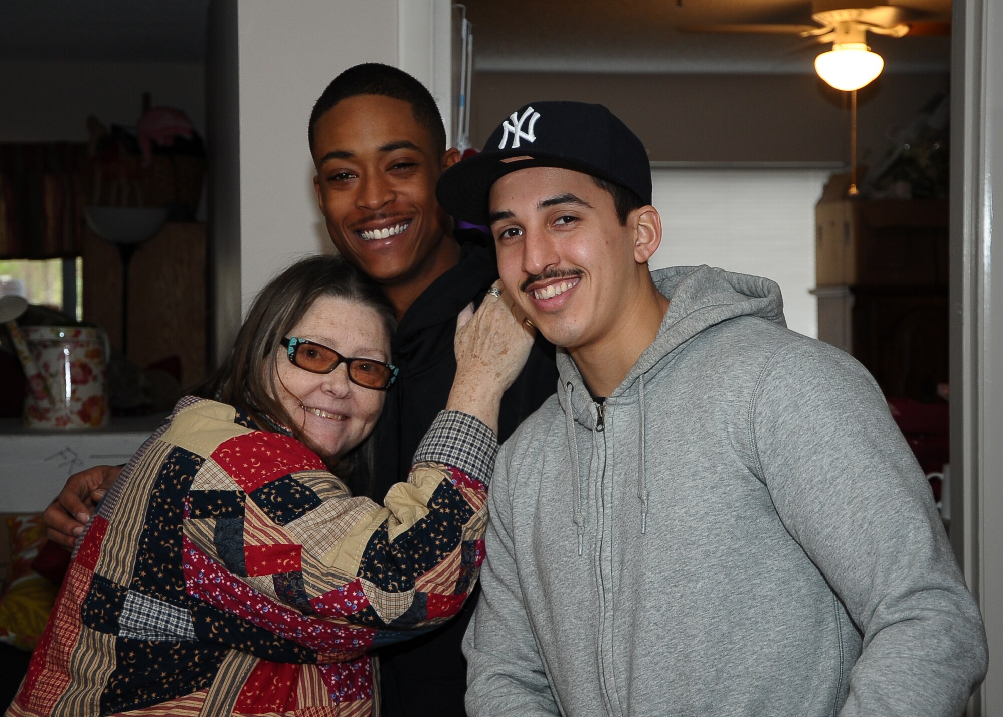 Senior Airman Morris Worship and Airman 1st Class Jason Rodriguez, both from the 14th Communications Squadron, pause for a photo with one of the residents of the Air Force Enlisted Village in her home after completing their “honey-do” lists Jan. 25. Many of the residents said that while they highly appreciated the help they received, they also loved having new faces to talk to and share their stories with. (U.S. Air Force Photo/Airman 1st Class Daniel Lile)