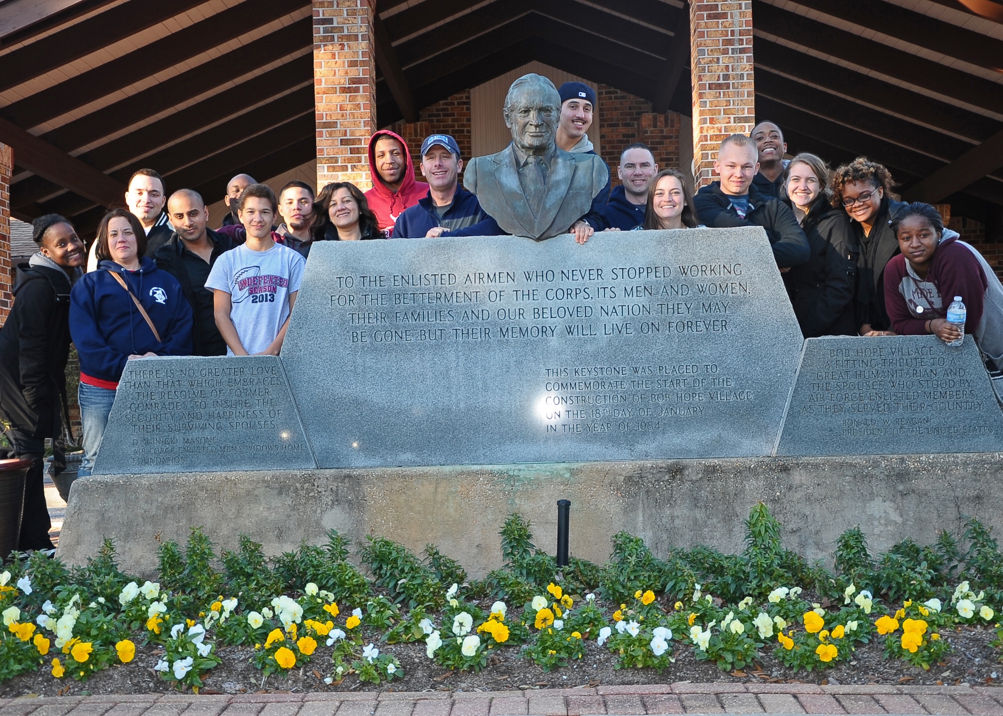 The group of 21 Airmen pause for a photo by the memorial for Bob Hope Jan. 25 in the Air Force Enlisted Village. (U.S. Air Force Photo/Airman 1st Class Daniel Lile)