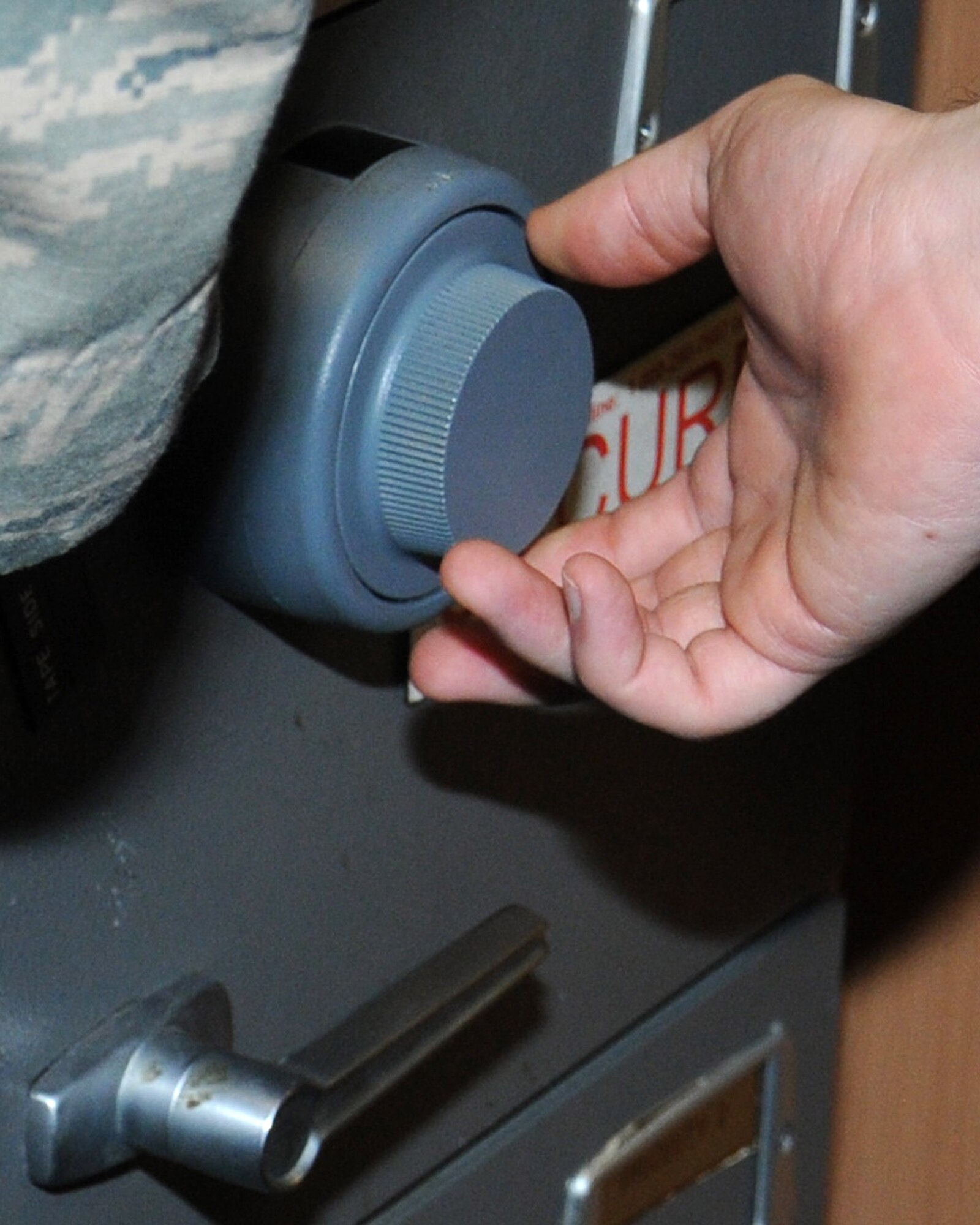 U.S. Air Force Airman 1st Class Matthew Mallin, 100th Communications Squadron Information Assurance technician from Hollywood, Fla., assigned to the 100th Air Refueling Wing IA Office, secures a safe Jan. 28, 2014, on RAF Mildenhall, England. The 100th ARW IAO Airmen ensure base members have the tools and training they need so they know what to look out for and stay cyber safe. The Airmen’s daily tasks ensure classified area countermeasures are secure; end-user workstation security, certification and accreditation of the domain; and validating IA controls to reduce vulnerabilities. (U.S. Air Force photo by Gina Randall/Released)