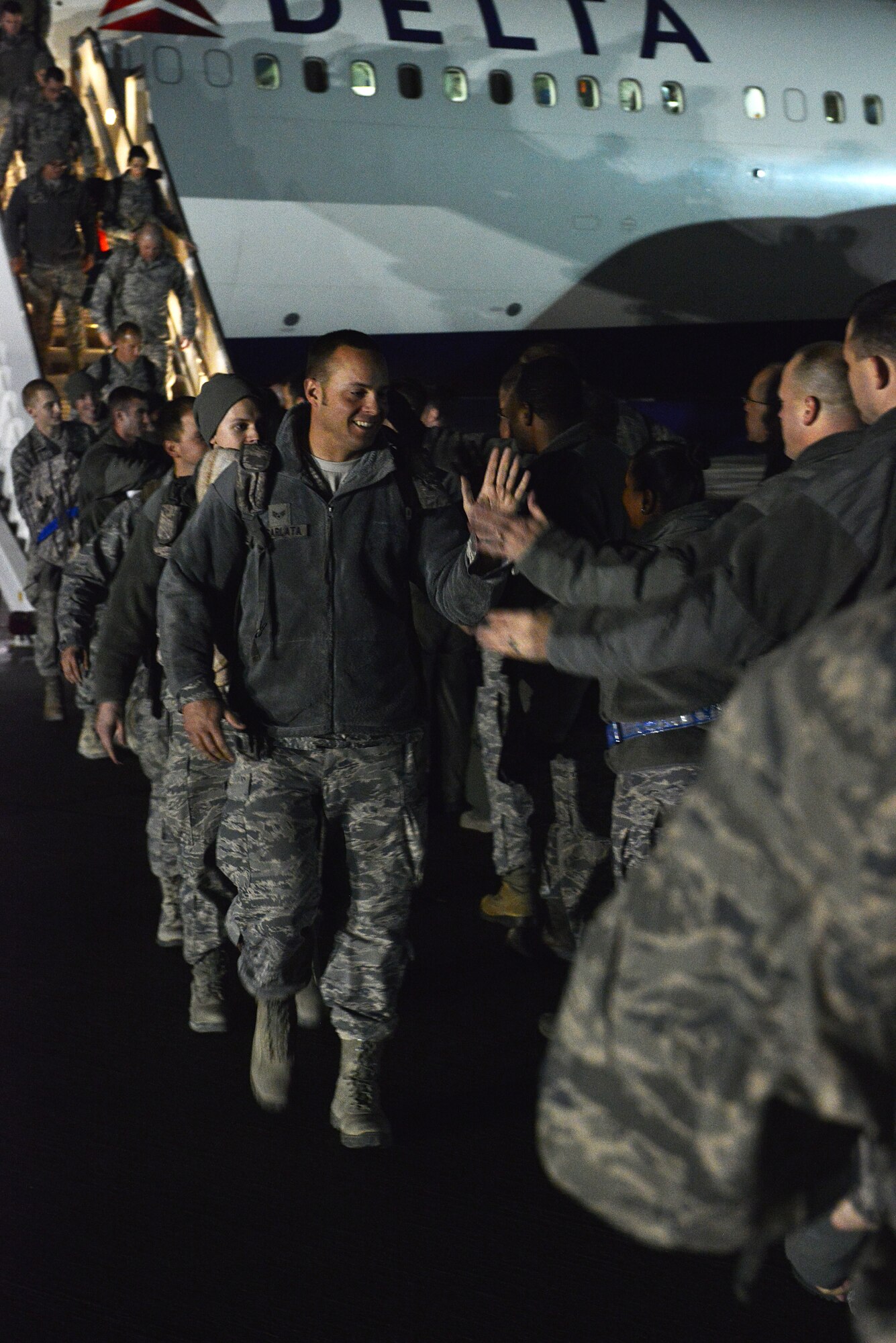 U.S. Air Force Senior Airman assigned to the 20th Fighter Wing high-fives a fellow Airman, after returning to Shaw Air Force Base, S.C., from a deployment, Feb. 7, 2014. The returning Airmen were greeted by commanders, supervisors and first sergeants immediately after getting off the aircraft. (U.S. Air Force photo by Airman 1st Class Jensen Stidham/Released)