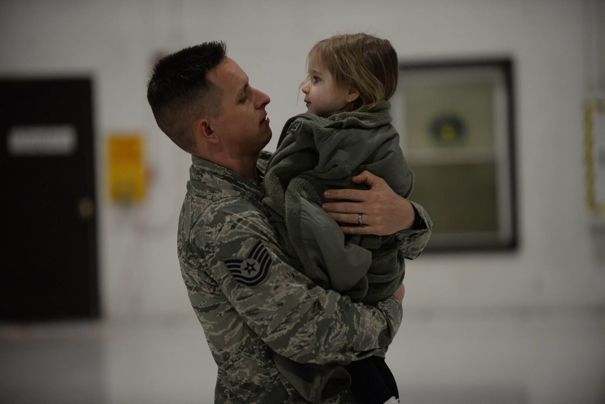 U.S. Air Force Tech. Sgt. Christopher Cummins, 20th Equipment Maintenance Squadron munitions technician, holds his daughter Harper Cummins after returning home from deployment, Feb. 7, 2014. Cummins returned home from a five-month deployment to his wife and daughter. (U.S. Air Force photo by Airman 1st Class Michael A. Cossaboom/released)
