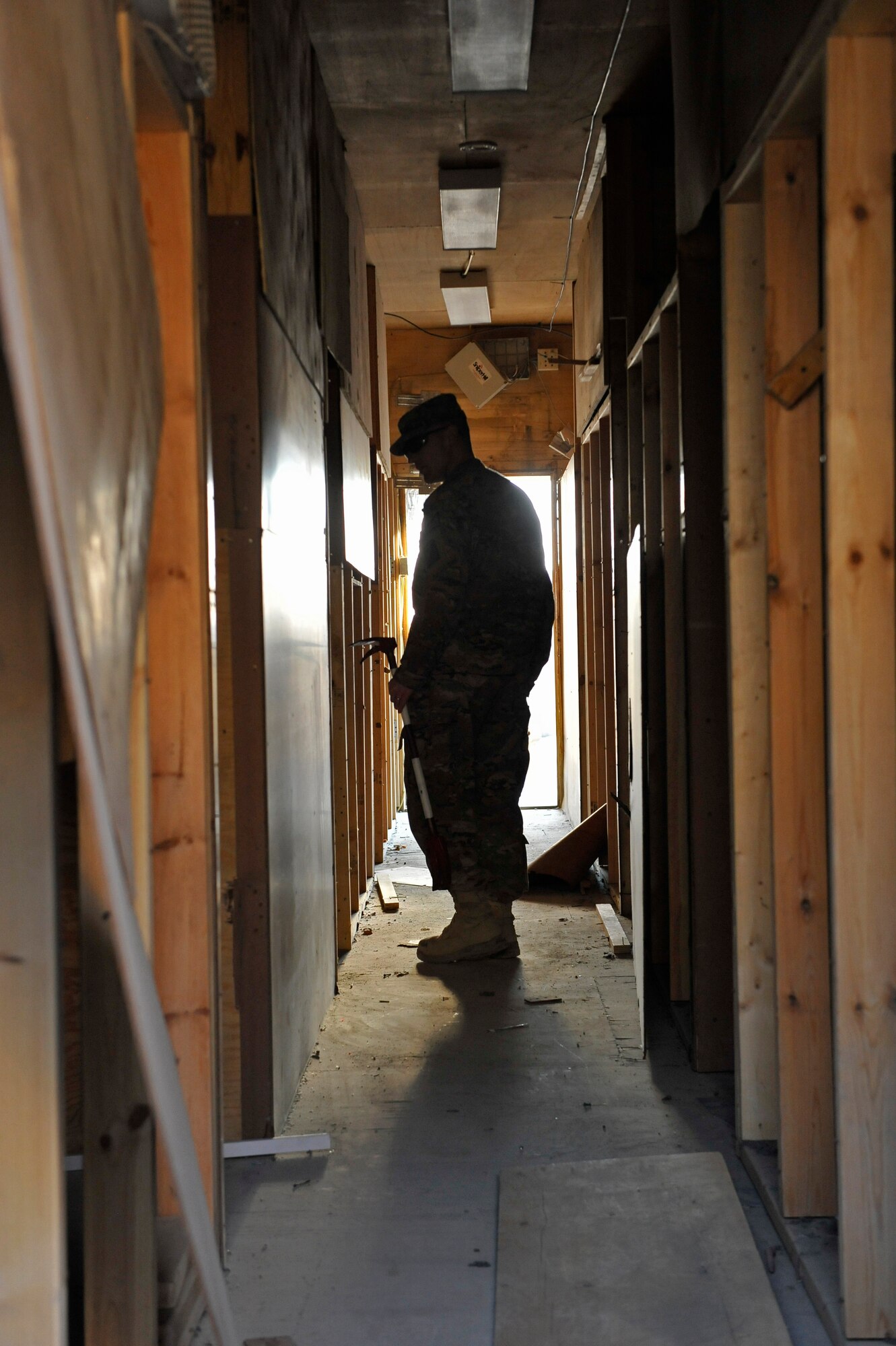 U.S. Air Force Staff Sgt. Rueben Gingerich walks down the hallway of a B-hut scheduled for demolition at Bagram Airfield, Afghanistan, Jan. 30, 2014. Gingerich is a member of a team responsible for identifying buildings to be torn down. One of their last tasks is to ensure the building is empty before final demolition begins.(U.S. Air Force photo by Senior Master Sgt. Gary J. Rihn/Released)