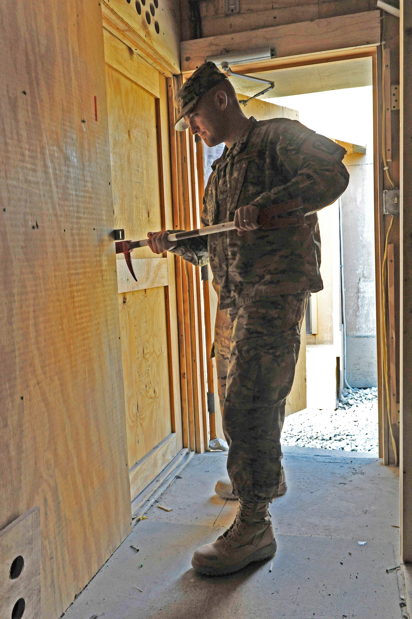 U.S. Air Force Staff Sgt. Rueben Gingerich uses a tool called a halligan to pop a latch on the door of a B-hut at Bagram Airfield, Afghanistan, Jan. 30, 2014. Gingerich is a member of a team responsible for identifying buildings to be torn down. One of their last tasks is to open all doors to ensure the building is empty before final demolition begins.(U.S. Air Force photo by Senior Master Sgt. Gary J. Rihn/Released)