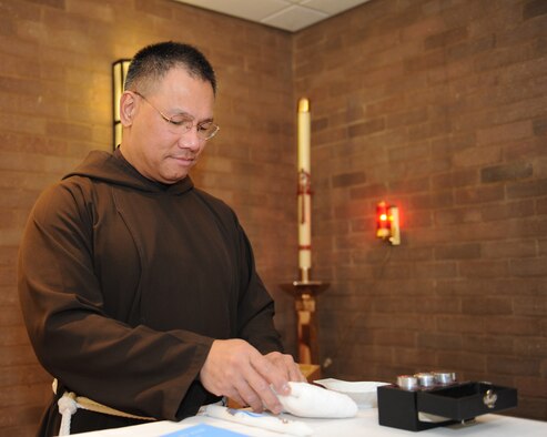 U.S. Air Force Chaplain (Capt.) Michael Tenorio, a Guam native assigned to the 100th Air Refueling Wing, prepares for a baptism Feb. 2, 2014, in the chapel on RAF Mildenhall, England. Tenorio wears the brown robes of The Order of Capuchin Friars Minor, an order of Franciscan Catholicism, when he’s not in uniform. (U.S. Air Force photo by Airman 1st Class Preston Webb/Released)