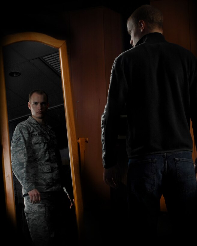 Senior Airman Chase Hedrick, 39th Air Base Wing Public Affairs photojournalist, observes his reflection Feb. 3, 2013, at Incirlik Air Base Turkey. Airmen are Airmen whether in uniform or not, and should ensure their conduct always meets and exceeds the standards of the Air Force they represent. (U.S. Air Force photo illustration by Airman 1st Class Nicole Sikorski/Released) 