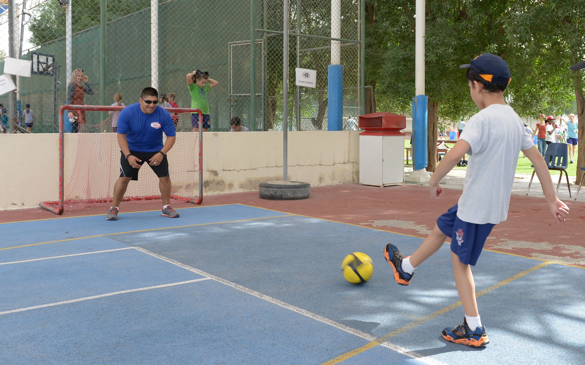 Tech. Sgt. Mario Coronado defends the goal from students at the American School of Doha in Qatar, during Sports Day, Feb. 2, 2014. Established in 2011, the Qatar National Sports Day prompted a government mandate that all schools develop a “sports day” the week prior to the national holiday to create awareness about sports and its health benefits in an effort to meet the challenges of a rapidly increasing youthful population. This year Qatar National Sports Day takes Feb. 11. Coronado is assigned to the 609th Air Communications Squadron Detachment 1 at Al Udeid Air Base, Qatar, and a Los Angeles, native deployed from Ramstein Air Base, Germany.  (U.S. Air Force photo/Senior Airman Hannah Landeros)