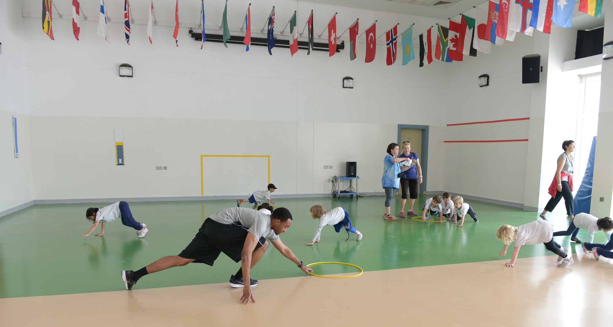 Airman 1st Class Justin Bynum demonstrates a bear crawl to students from the American School of Doha in Qatar, during Sports Day, Feb. 2, 2014. Established in 2011, the Qatar National Sports Day prompted a government mandate that all schools develop a “sports day” the week prior to the national holiday to create awareness about sports and its health benefits in an effort to meet the challenges of a rapidly increasing youthful population. This year Qatar National Sports Day takes place Feb. 11. Bynum is assigned to the 609th Air Communications Squadron Detachment 1 at Al Udeid Air Base, Qatar, and a Bessemer, Ala., native deployed from Offutt Air Force Base, Neb. (U.S. Air Force photo/Senior Airman Hannah Landeros)