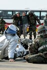 Wolf Pack responders carry an exercise role player to safety during exercise Beverly Midnight 14-01 at Kunsan Air Base, Republic of Korea, Feb. 7, 2014. The Wolf Pack responded to a mass casualty situation caused by a simulated bus explosion on the flight line. (U.S. Air Force photo by Staff Sgt. Jessica Haas/Released)
