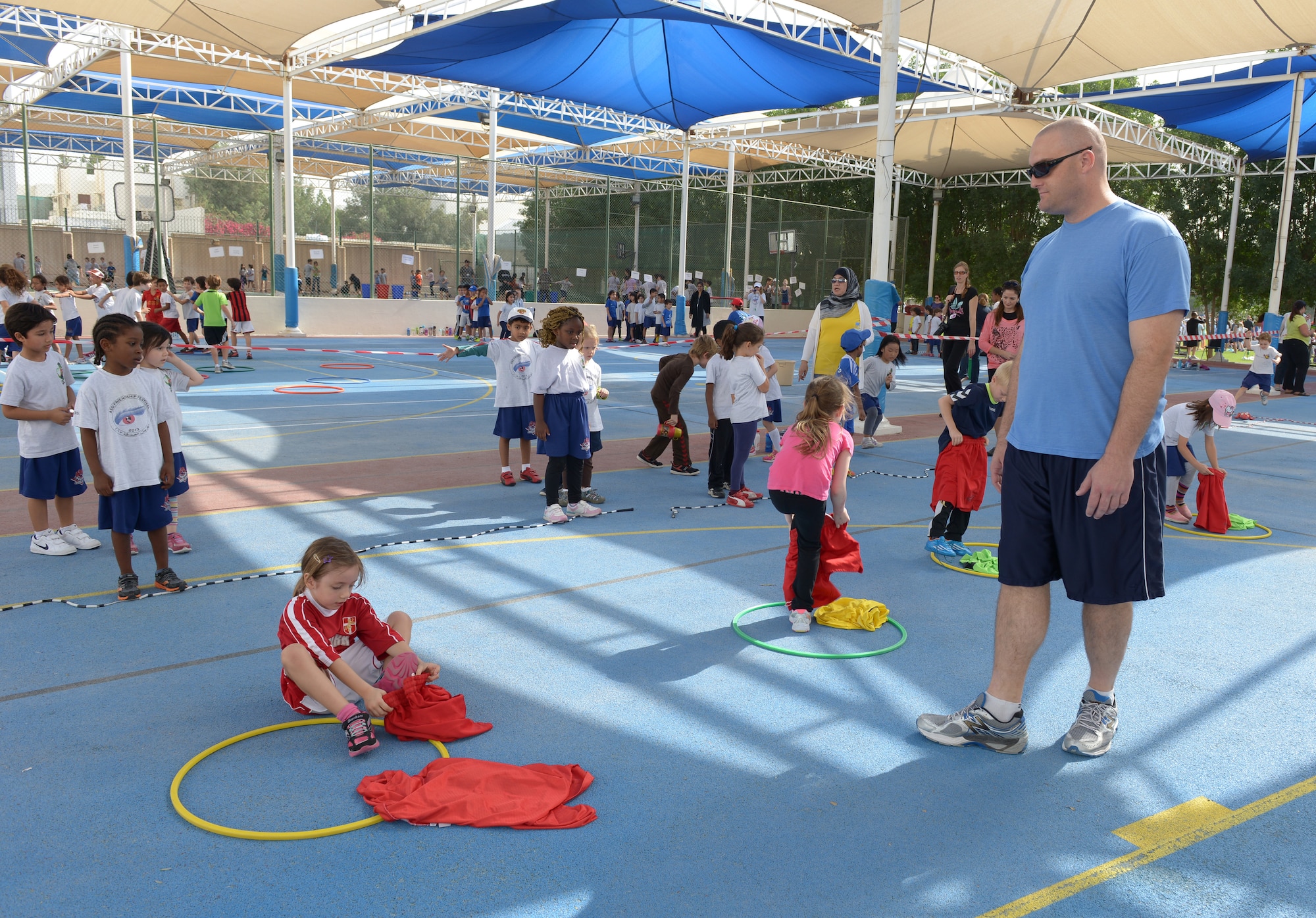 Capt. Joseph Clark explains the rules for his activity to students, from the American School of Doha in Qatar, during Sports Day, Feb. 2, 2014. Established in 2011, the Qatar National Sports Day prompted a government mandate that all schools develop a “sports day” the week prior to the national holiday to create awareness about sports and its health benefits in an effort to meet the challenges of a rapidly increasing youthful population. This year Qatar National Sports Day takes place Feb. 11. Clark is assigned to the 379th Expeditionary Operations Support Squadron at Al Udeid Air Base, Qatar, and a Fairfield, Calif., native deployed from Beale Air Force Base, Calif. (U.S. Air Force photo/Senior Airman Hannah Landeros)