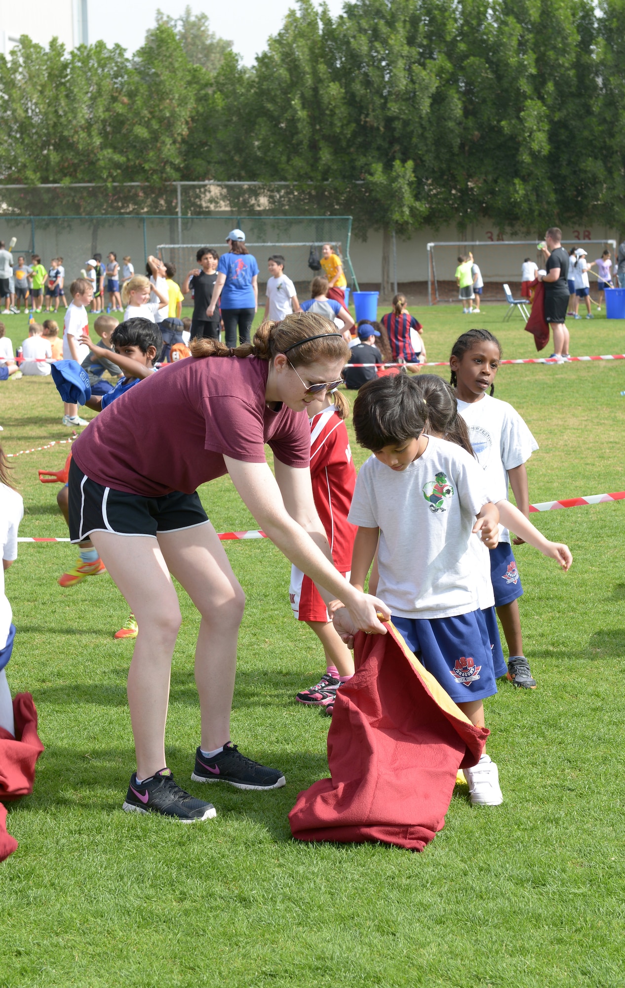 2nd Lt. Katharine Donovan helps a child, from the American School of Doha in Qatar, prepare for a sack race during Sports Day, Feb. 2, 2014. Established in 2011, the Qatar National Sports Day prompted a government mandate that all schools develop a “sports day” the week prior to the national holiday to create awareness about sports and its health benefits in an effort to meet the challenges of a rapidly increasing youthful population. This year Qatar National Sports Day takes place Feb. 11. Donovan is serving a one year tour with 609 Air Operations Center Intelligence, Surveillance and Reconnaissance Division at Al Udeid Air Base, Qatar, and is a Chesapeake, Va., native. (U.S. Air Force photo/Senior Airman Hannah Landeros)