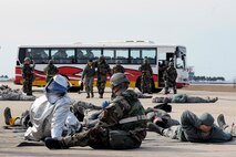 Wolf Pack responders carry exercise role players to safety during exercise Beverly Midnight 14-01 at Kunsan Air Base, Republic of Korea, Feb. 7, 2014. The Wolf Pack responded to a mass casualty situation caused by a simulated bus explosion on the flight line. (U.S. Air Force photo by Staff Sgt. Jessica Haas/Released)