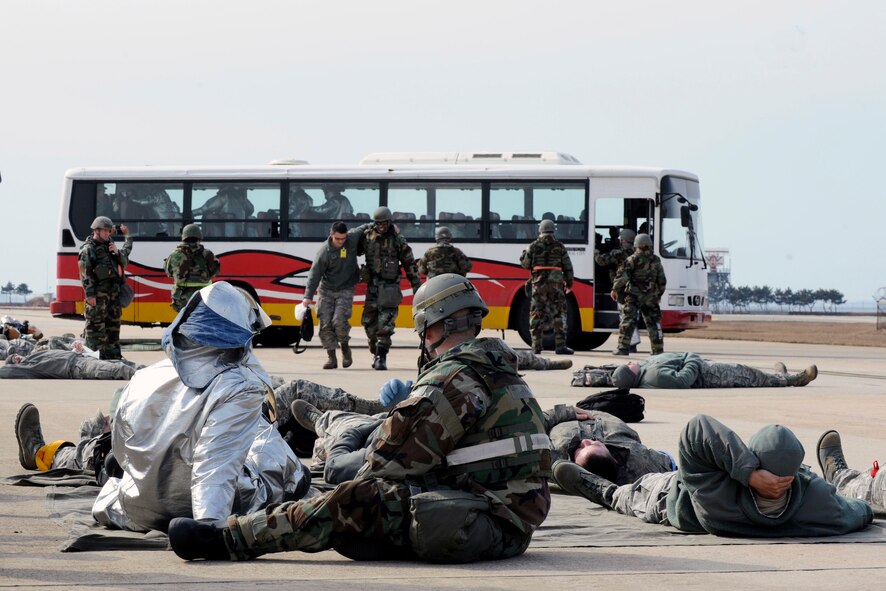 Wolf Pack responders carry exercise role players to safety during exercise Beverly Midnight 14-01 at Kunsan Air Base, Republic of Korea, Feb. 7, 2014. The Wolf Pack responded to a mass casualty situation caused by a simulated bus explosion on the flight line. (U.S. Air Force photo by Staff Sgt. Jessica Haas/Released)