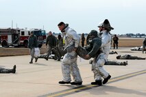 Wolf Pack firefighters carry exercise role players to safety during exercise Beverly Midnight 14-01 at Kunsan Air Base, Republic of Korea, Feb. 7, 2014. The Wolf Pack responded to a mass casualty situation caused by a simulated bus explosion on the flight line. (U.S. Air Force photo by Staff Sgt. Jessica Haas/Released)
