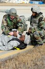Wolf Pack responders aid an exercise role player during Beverly Midnight 14-01 at Kunsan Air Base, Republic of Korea, Feb. 7, 2014. The Wolf Pack responded to a mass casualty situation caused by a simulated bus explosion on the flight line. (U.S. Air Force photo by Staff Sgt. Jessica Haas/Released)